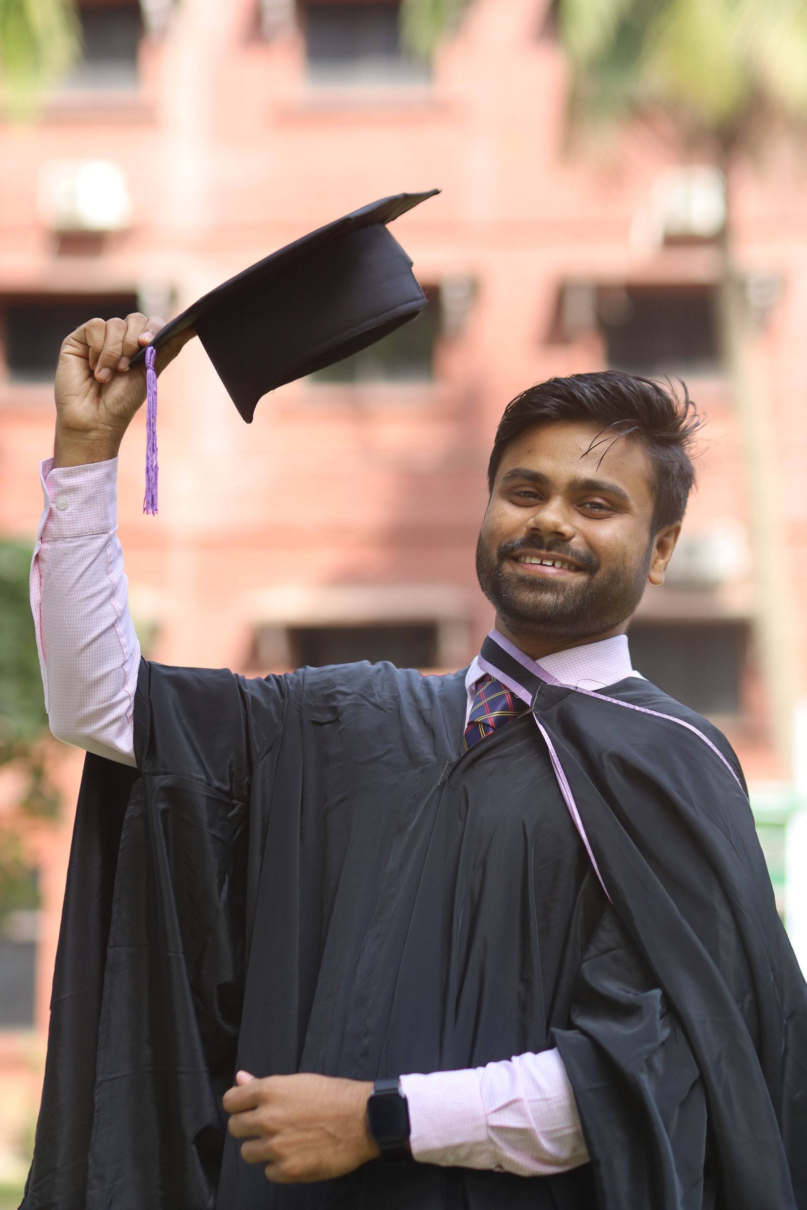A student smiling while checking their exam result on a phone.